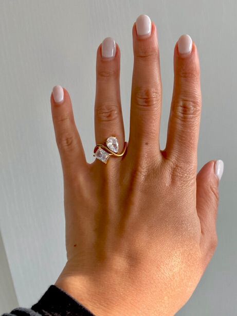✨ You & Me Luxe Gold Ring ✨ Pear + Emerald Cut Zircon  A true statement of modern romance. This high-end “you and me” ring pairs a luminous pear-cut stone with a crisp emerald-cut zircon, symbolising two souls aligned. The sculptural gold setting wraps el