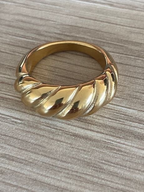 ✨ Twisted Gold Glow Ring – Quiet Luxury Essential  Sculptural, glossy, and effortlessly elevated, this size 7 ring is crafted from 18K gold-filled stainless steel that looks like real gold and acts like it too. Waterproof, tarnish-free, hypoallergenic, an