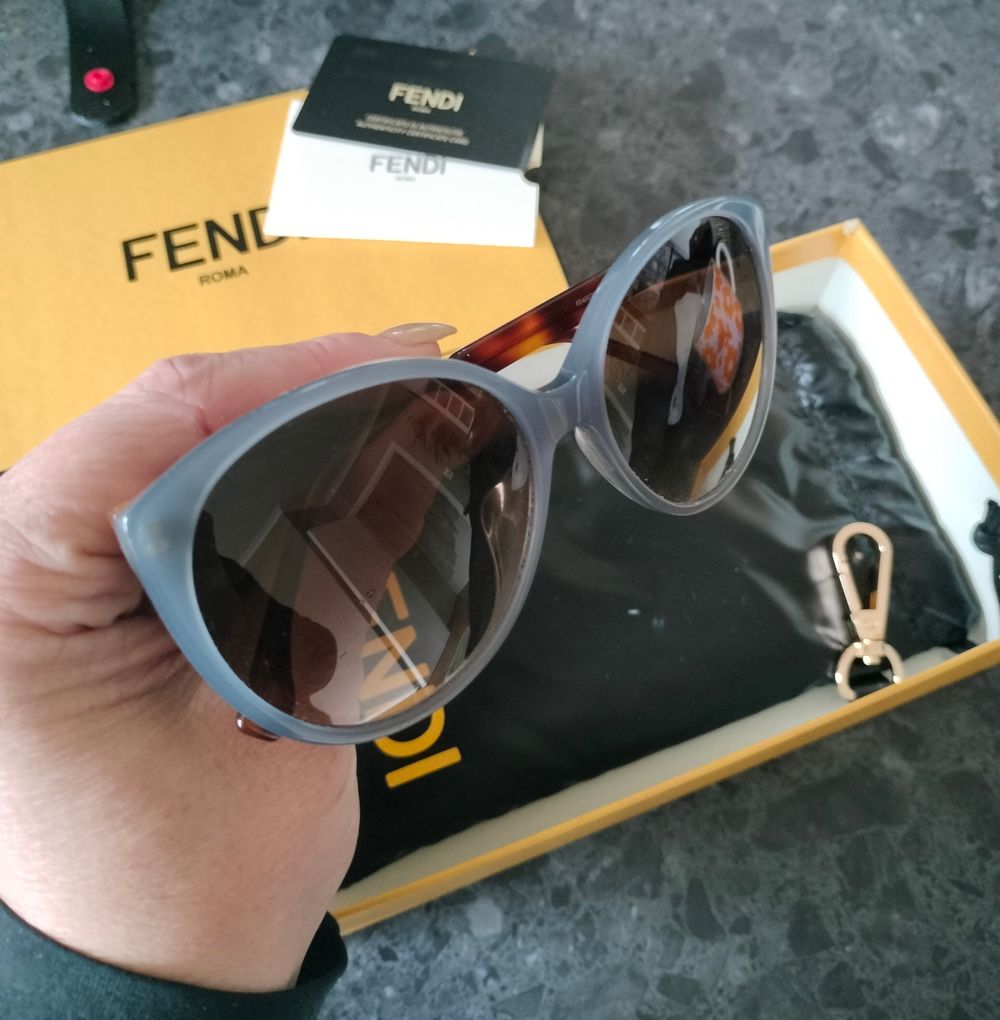 Fendi sunglasses with blue gray frames and tortoise arms.