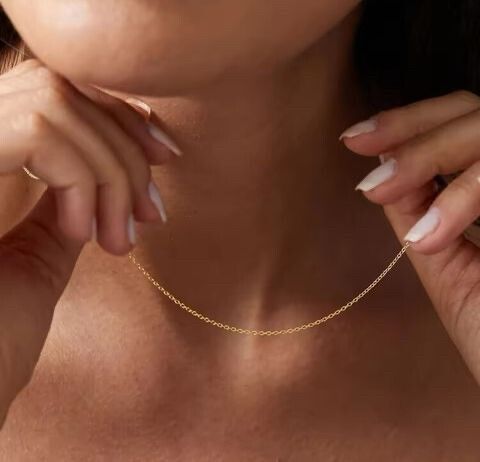 Dainty Gold Necklace – Minimalist Elegance  A delicate, high-end piece designed for effortless layering and everyday wear. 	•	18k gold-filled stainless steel – waterproof, tarnish-free, hypoallergenic, and never fades. 	•	Ultra-dainty and lightweight – pe